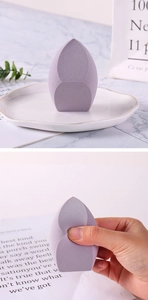 Gros plan sur l'éponge de maquillage violette montrant l'élasticité et la texture douce