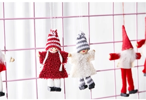 Detail of cute knitted angel dolls with plush dresses and striped hats for Christmas trees