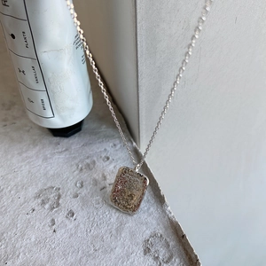 Detailed macro view of 925 silver irregular rectangle pendant with hammered texture