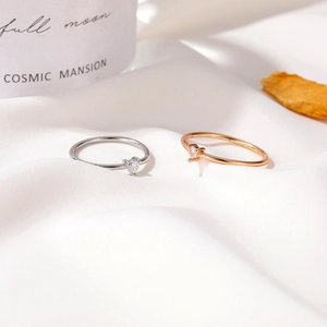 Minimalist heart-shaped zircon rings in silver and rose gold on white silk fabric