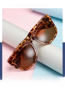 Detail of tortoiseshell oversized sunglasses with gradient brown lenses on colorful background