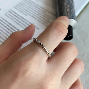 Macro detail of 925 sterling silver twisted rope ring on model with minimalist props
