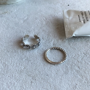 Detailed close-up of S925 sterling silver retro daisy ring and braided twist band ring