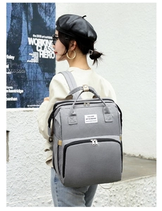 Detail of grey multifunctional backpack featuring large capacity main pocket and wide straps