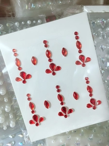 Macro shot of red acrylic facial rhinestone stickers in teardrop and round gem patterns