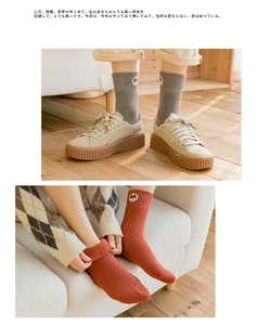 Close-up of thick ribbed cotton socks with animal embroidery patches on the cuffs
