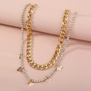 Macro detail of a golden double-layered butterfly necklace with rhinestones and flat links