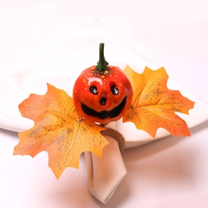 Halloween pumpkin and maple leaf napkin ring with rustic jute twine on white napkin