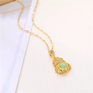 Golden hollow gourd necklace with green jade stone and sparkling crystals on white background