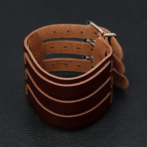 Detail view of brown multilayer leather motorcycle wristband with metallic buckle closure