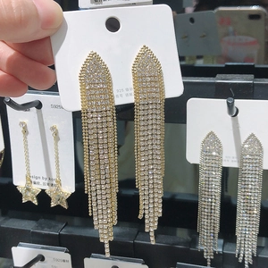 Detail of long gold tassel earrings with sparkling rhinestones and 925 silver needles