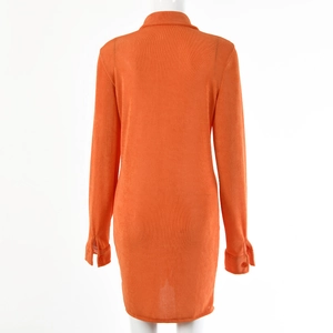 Rear view of orange corduroy shirt dress showing lapel collar and buttoned cuffs