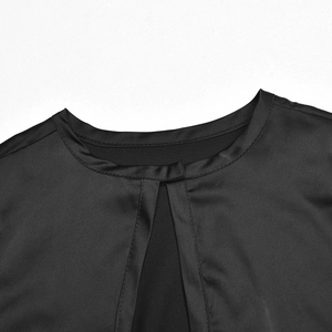 Detail of a black satin crop top featuring a round neckline and vertical slit cutout