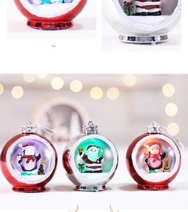 Close-up of LED Christmas ornaments with Santa figurines and artificial snow inside