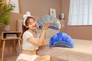 Plush pill bug toy set in blue and gray displayed in a cozy lifestyle bedroom setting
