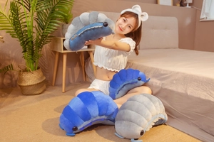 Detailed view of gray and blue woodlouse plush toys in various sizes on a bed