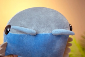 Macro shot of soft plush fabric and stitched eyes on a caterpillar stuffed toy pillow