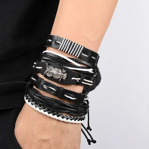 Close-up of stacked vintage braided leather bracelets with a metal owl charm for men