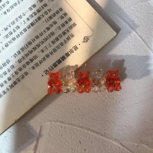 Korean style hair clip with five colorful resin bears on an open book background