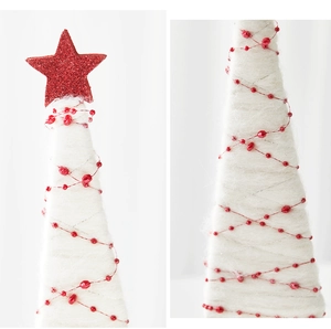 Detail of Nordic wool felt Christmas tree with red beads and glittery star topper