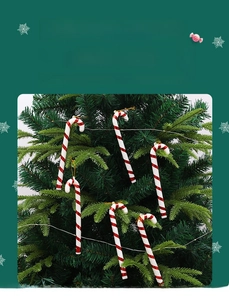 Detail of red and white candy cane ornaments with gold hanging strings on a Christmas tree