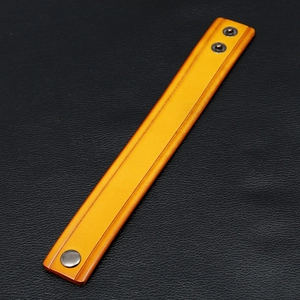 Detail of yellow leather bracelet featuring three metal snap buttons on black background