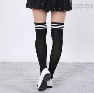 Detail of black over-the-knee dance socks with three white stripes on back view