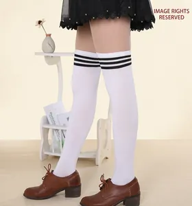 Close-up of white over-the-knee socks with three black stripes in a cozy home setting