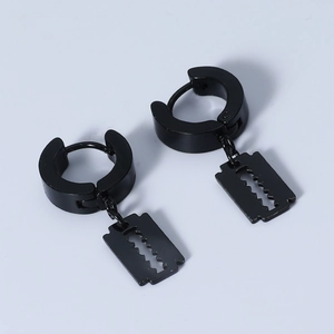 Detail of black huggie hoop earrings with razor blade pendants in polished finish