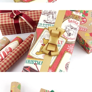 Detail of Christmas wrapping paper featuring red plaid and Santa Claus with luxury silk ribbons