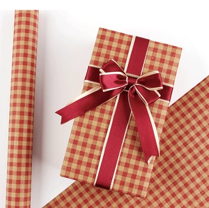 Close-up of red gingham kraft gift wrap with deep red satin ribbon and champagne gold edges