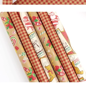 Detail of vintage kraft gift wrapping paper with Christmas motifs and red plaid patterns