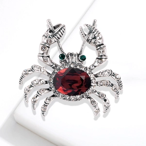 Crab brooch with large oval red gemstone and clear rhinestones on a silver metal base