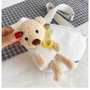 Close-up of white canvas chest bag featuring a plush teddy bear and JIA BAG logo