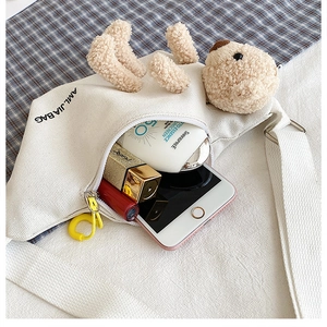 Detail showing white canvas crossbody bag interior capacity with cute plush bear decor