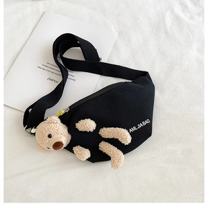 Close-up of black canvas chest bag with 3D plush bear ornament and white brand logo