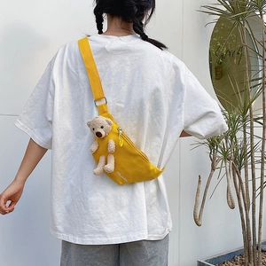 Model view showing the yellow canvas chest bag with a cute plush bear on the back