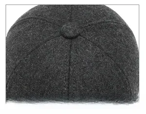 Close-up of the meticulous stitching and top button on a grey winter baseball cap