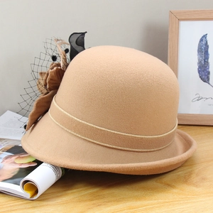 Détail d'un chapeau en feutre de laine avec voile en résille et accents de fleurs en tissu