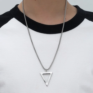 Close-up of minimalist silver triangle pendant with box chain worn on model's neck