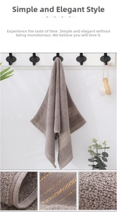 Detail showing plush dark grey cotton towel texture with elegant gold stripe embroidery