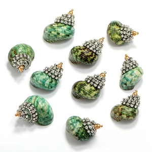 Detailed view of green spiral shell pendants with sparkling inlaid rhinestones for jewelry