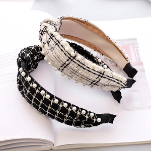 Detail of tweed knotted headband with pearls on magazine background