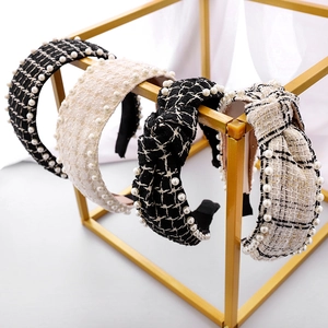 Detailed view of tweed headbands with faux pearl trim in black and beige knots