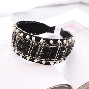 Detail of tweed headband with white pearls on a book page background