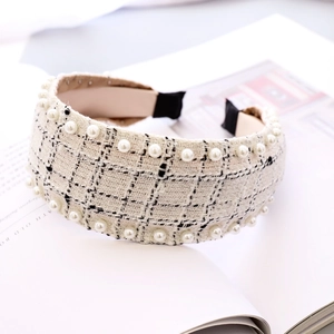 Detailed view of the cream tweed headband texture with white pearl accents and woven pattern