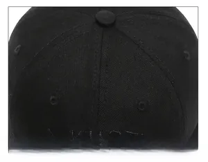 Detail shot of the six-panel crown stitching and eyelets on a black cotton baseball cap