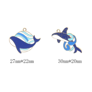Detailed macro view of whale enamel charms in blue and gold with 27mm and 30mm dimensions