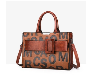 Detail of retro brown tote bag with embossed letter patterns and adjustable strap