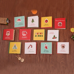 Flat lay of mini Christmas cards with gold stamping on a dark wood background